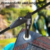 Close-up of a black elastic tie-down strap with hooks being used to secure a textured surface.