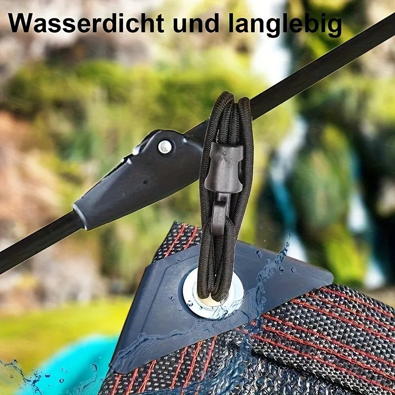 Close-up of a black elastic tie-down strap with hooks being used to secure a textured surface.