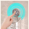 A hand rotates a clear wall-mounted suction cup storage basket with a water ripple design.