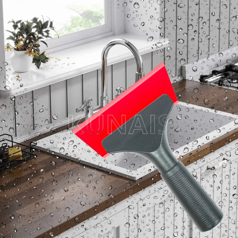 A red and gray scraper tool is shown positioned over a kitchen sink, with water droplets visible on the surrounding surfaces.