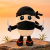 A black and white plush toy of a shark with a mask and swords standing on a rock against an orange sunset background.