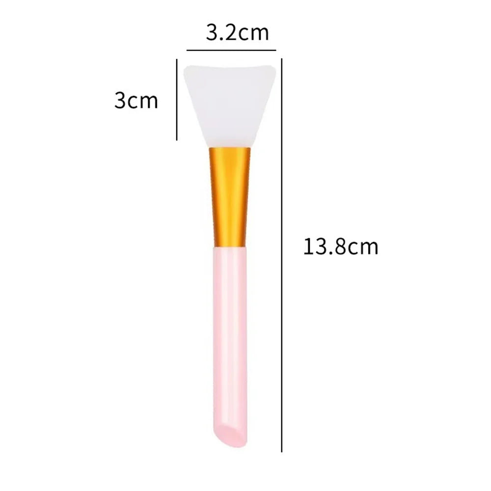A pink silicone facial mask brush with a white applicator tip and gold handle, shown next to dimension lines.