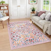 A vintage floral soft area rug featuring pink, orange, and green botanical patterns in a living room setting.