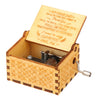 A vintage hand-cranked wooden music box with a lid open, featuring a handwritten note inside.