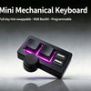 A close-up view of a black mini mechanical keyboard with purple RGB backlighting and a round multimedia knob.
