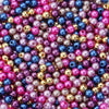 A close-up of numerous round imitation pearl beads in various shades of pink, purple, blue, and gold.