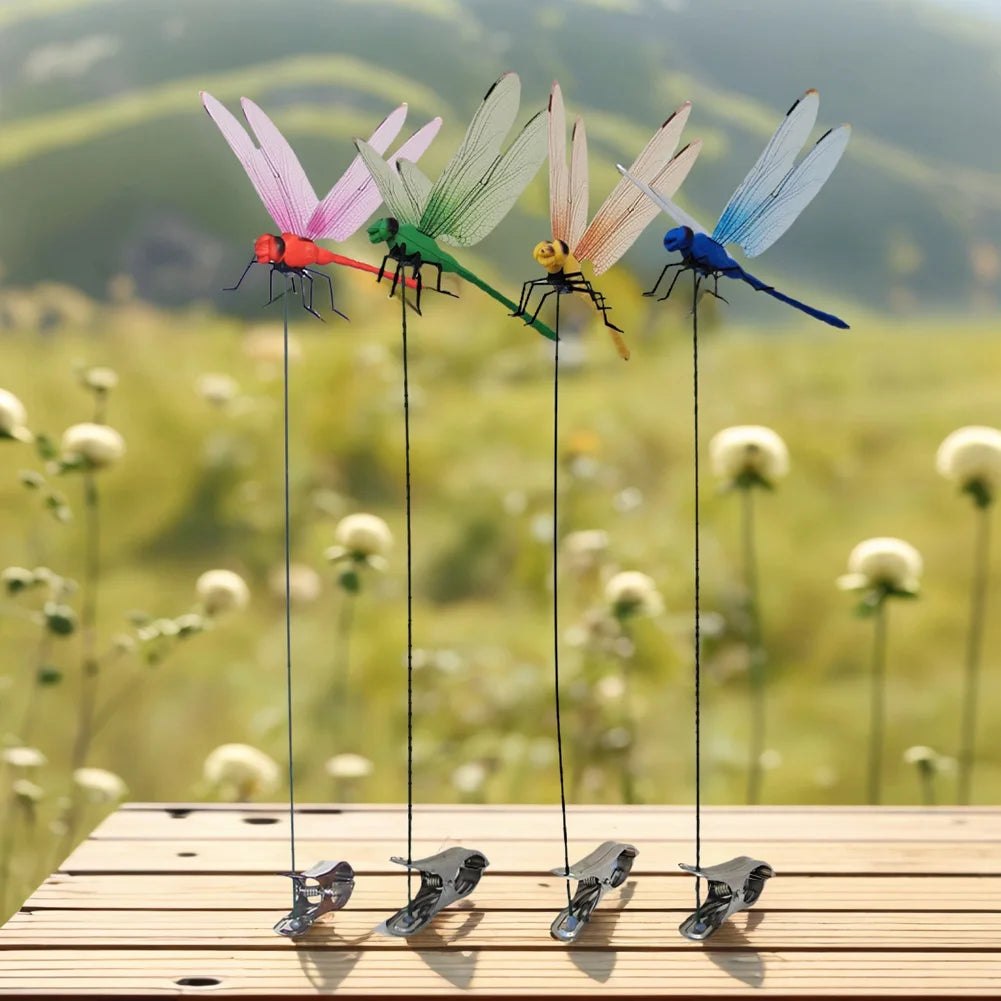 Five lifelike dragonfly garden clips with insect repellent designs hanging from thin wires on a wooden surface.