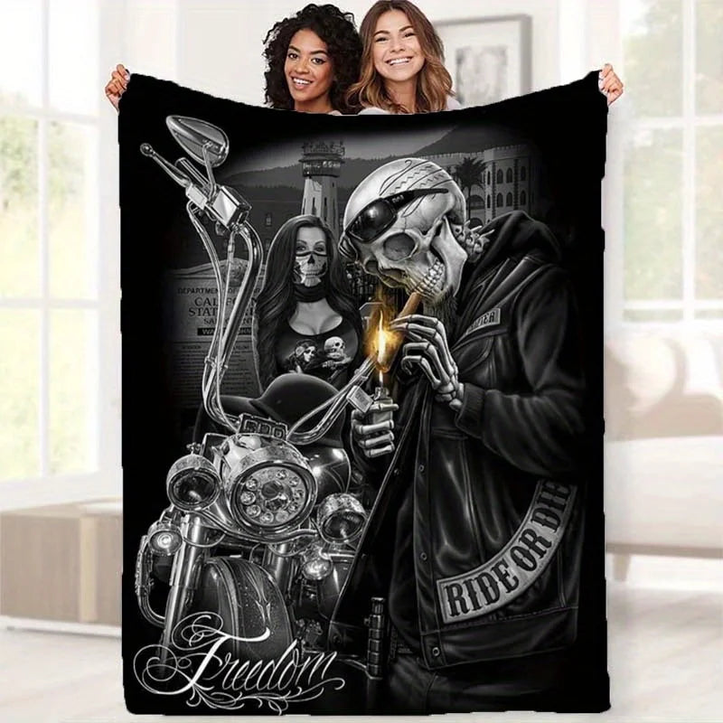 A black print featuring a skull and female figure in a biker style on a flannel throw blanket.