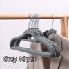 Grey non-slip velvet hangers with multiple hooks displayed on a wooden hanger.