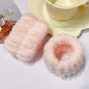 Pink microfiber wrist sweatband and scrunchies for face washing displayed on a white surface.
