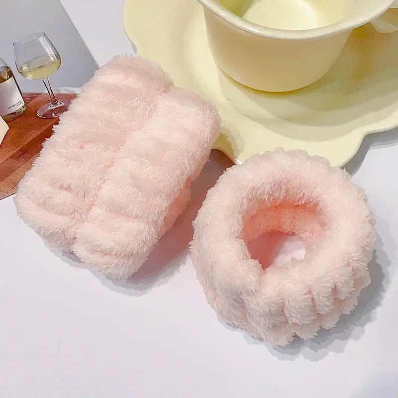 Pink microfiber wrist sweatband and scrunchies for face washing displayed on a white surface.