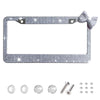 Silver rhinestone license plate frame with a bow accent and mounting hardware