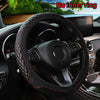 A black leather steering wheel with a diamond-stitched cover is shown inside a car, featuring an inner ring detail.