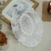 Elegant oval white lace embroidered placemat displayed on a light surface.