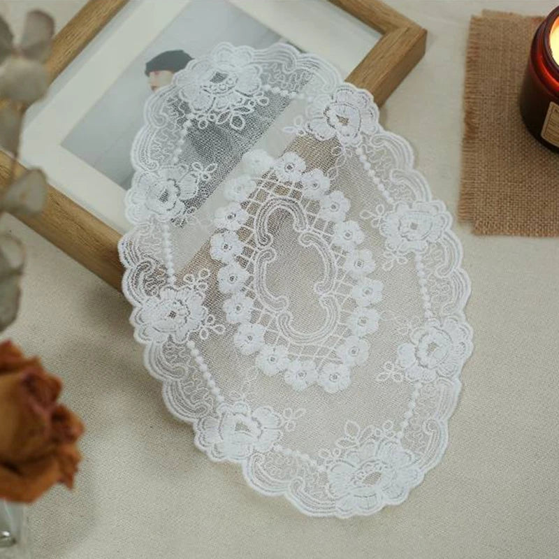 Elegant oval white lace embroidered placemat displayed on a light surface.