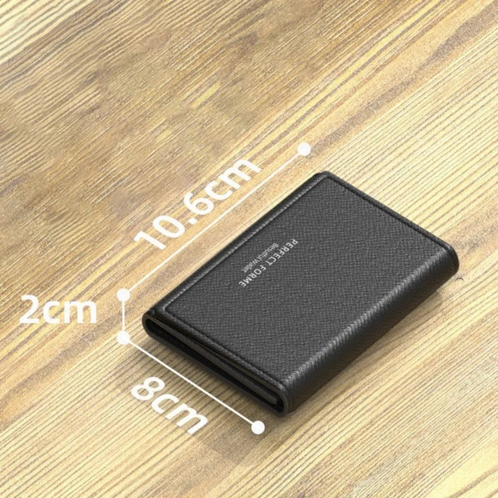 A black leather card holder wallet is shown on a wooden surface with dimensions marked.