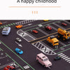 A black and yellow cartoon car traffic play mat with various toy cars on a dark surface.