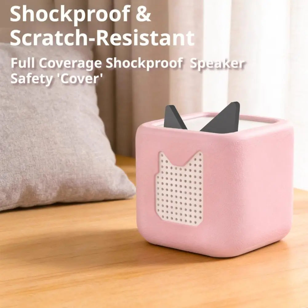 A pink silicone shockproof cover for a speaker or audio player is shown on a wooden surface.
