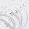 A collection of six silver-plated nylon guitar strings are laid out on a white surface, numbered one through six.