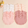 A set of three soft cotton ruffle bibs in white, peach, and dusty rose pink for babies.