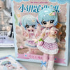 A collection of two light blue and pink articulated BJD collectible figurines packaged in a box.