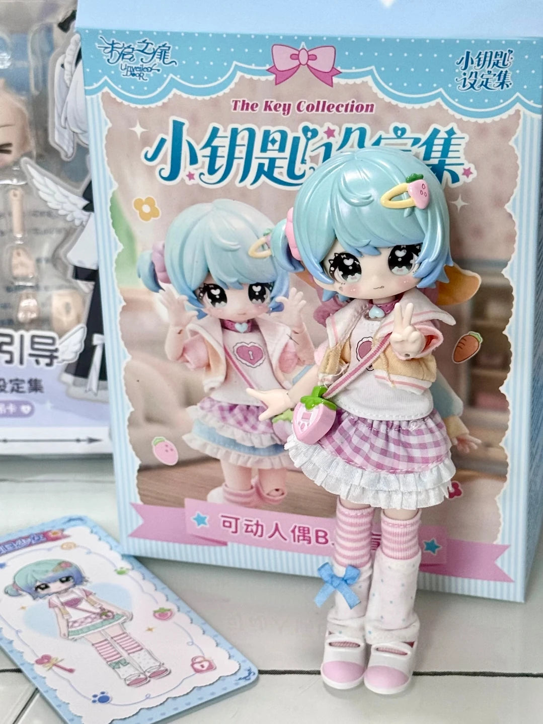 A collection of two light blue and pink articulated BJD collectible figurines packaged in a box.