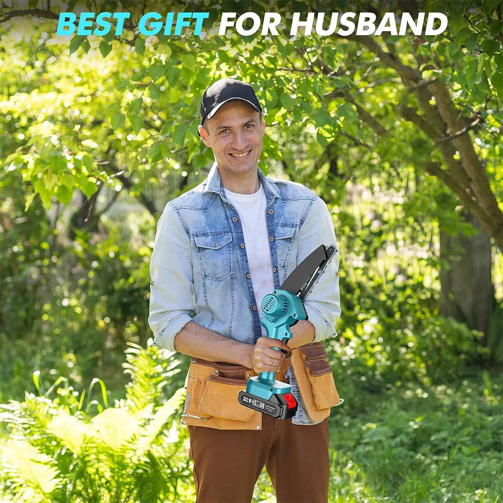 A man wearing a baseball cap and denim shirt holds a blue cordless mini chainsaw in an outdoor garden setting.