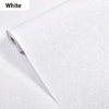 Roll of white embossed silk self-adhesive wallpaper being unrolled.