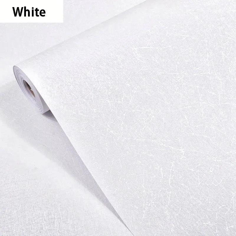 Roll of white embossed silk self-adhesive wallpaper being unrolled.