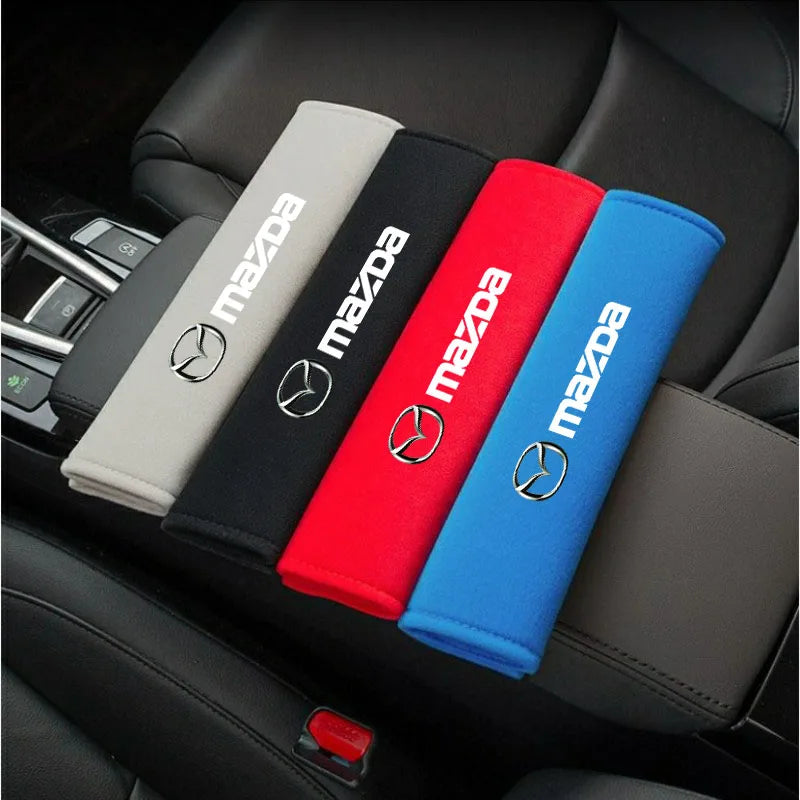 A set of five colored soft cotton car seat belt shoulder protector covers displayed in a car interior.