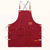 A maroon canvas kitchen apron with straps and large front pockets.