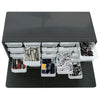 A black wall-mounted parts organizer with multiple clear plastic drawers for storing small components.