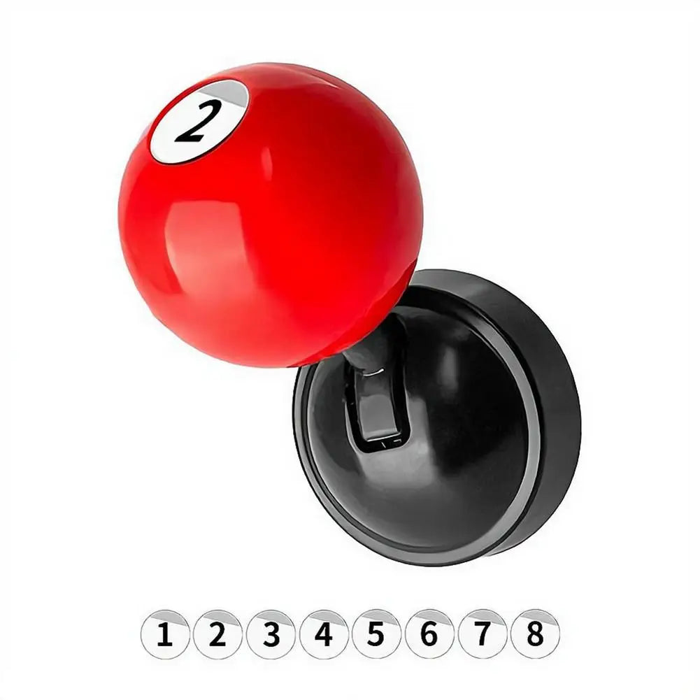 A red billiard ball shaped metal push-to-start button cover with the number 2, shown next to its black base.