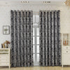 A pair of patterned black and white tree bark jacquard blackout curtain panels hanging in a light-colored room.
