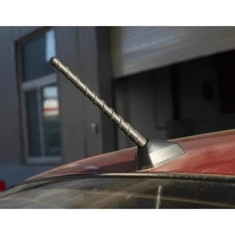 A close-up view of a direct replacement car antenna with a threaded mounting post installed on a vehicle roof.