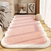 A pink and white striped plush decorative area rug laid out on a wooden floor.