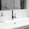 A close-up of a modern chrome faucet mounted on a white bathroom sink.