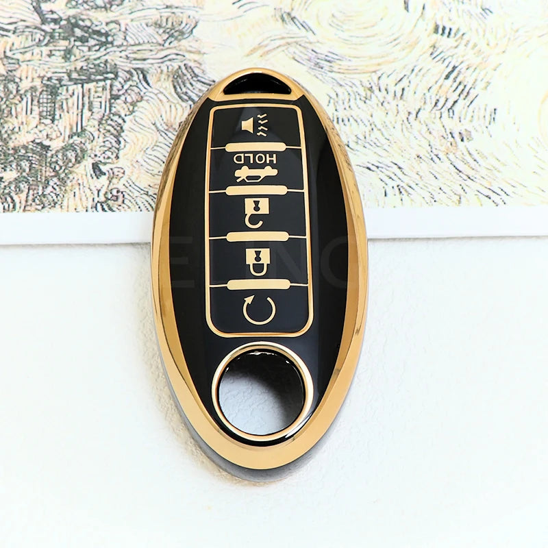 A close-up of a black and gold soft TPU car key fob cover with five buttons for a Nissan vehicle.