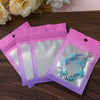 A set of gradient pink and purple resealable zipper pouches with clear windows containing jewelry.