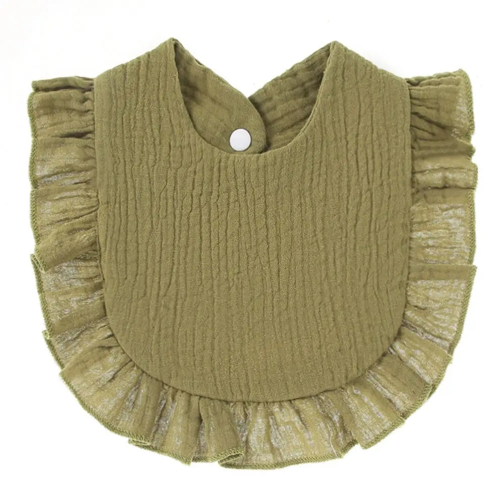 A soft olive green cotton baby bib in a bandana style with ruffled edges and a small button.
