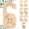 A set of eight wooden baby closet dividers for organizing clothes, ranging in size from newborn to 24 months.