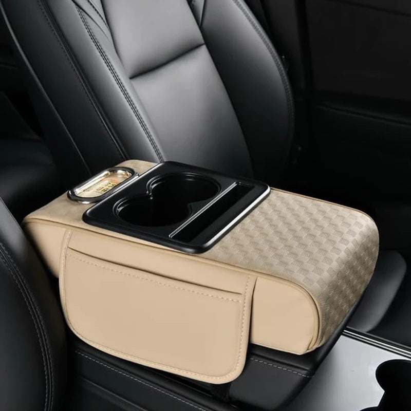 A beige car armrest cushion with a black cupholder and storage compartment is shown in a vehicle interior.
