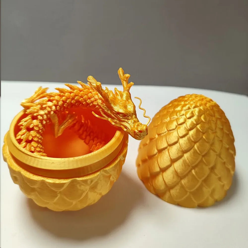 A golden dragon figurine with a glowing orange egg inside, displayed on a white surface.