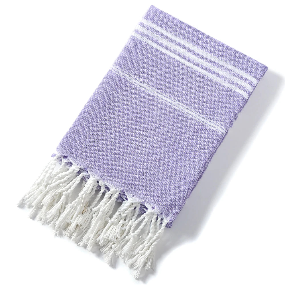 A purple striped cotton beach towel with white fringe.