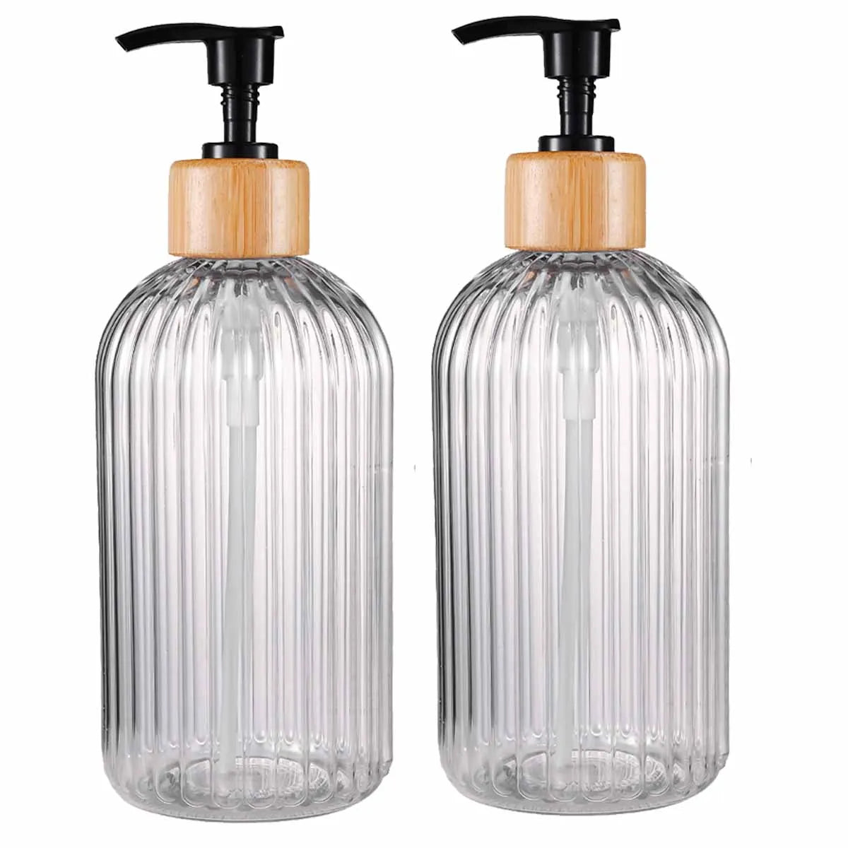 A pair of clear glass refillable soap dispensers with wooden caps and black pump tops.