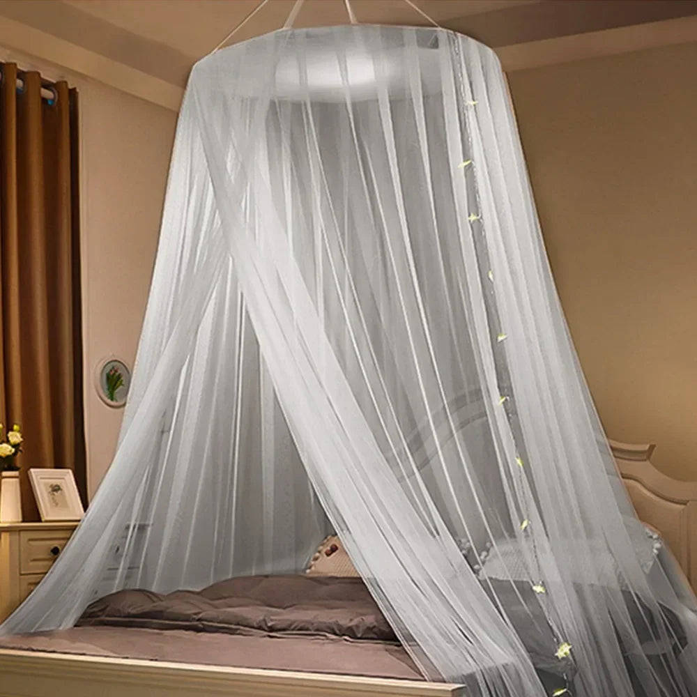 A sheer gray mosquito net canopy draped over a double bed in a bedroom setting.