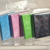 A collection of holographic heart-shaped card sleeves in various pastel and bright colors displayed in clear plastic packagin
