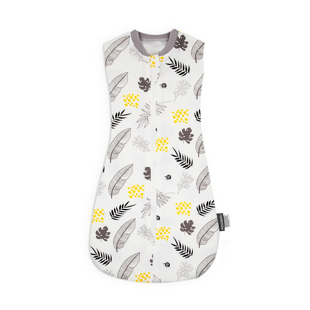 A white baby sleep sack featuring a pattern of green and yellow leaves on a gray fabric.