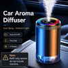 A blue and orange car aroma diffuser with an ambient light feature resting on a car interior surface.