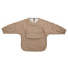 A beige waterproof long-sleeve smock for toddlers with a chest pocket.